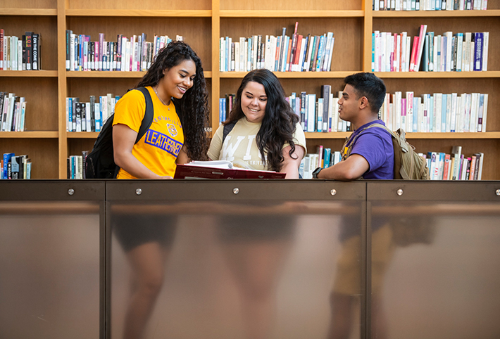 A couple of students in a library. Link to Gifts That Protect Your Assets.